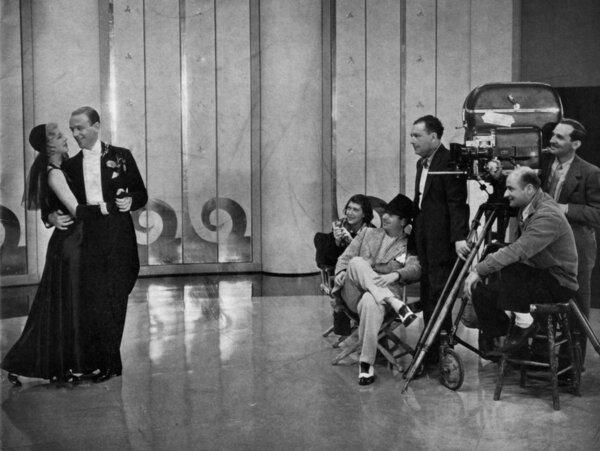 Tournage de "L'Entreprenant M. Petrov" en 1937 - De gauche à droite : Ginger Rogers et Fred Astaire, le réalisateur Mark Sandrich (assis), le chef opérateur David Abel (debout en costume sombre) et Joseph Biroc derrière la caméra